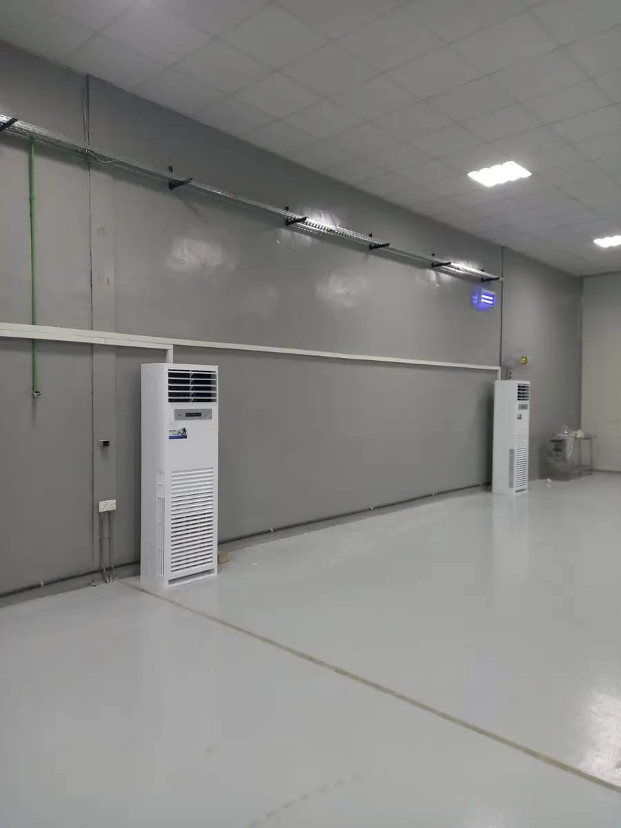 Floor-standing air conditioners installed along a warehouse wall